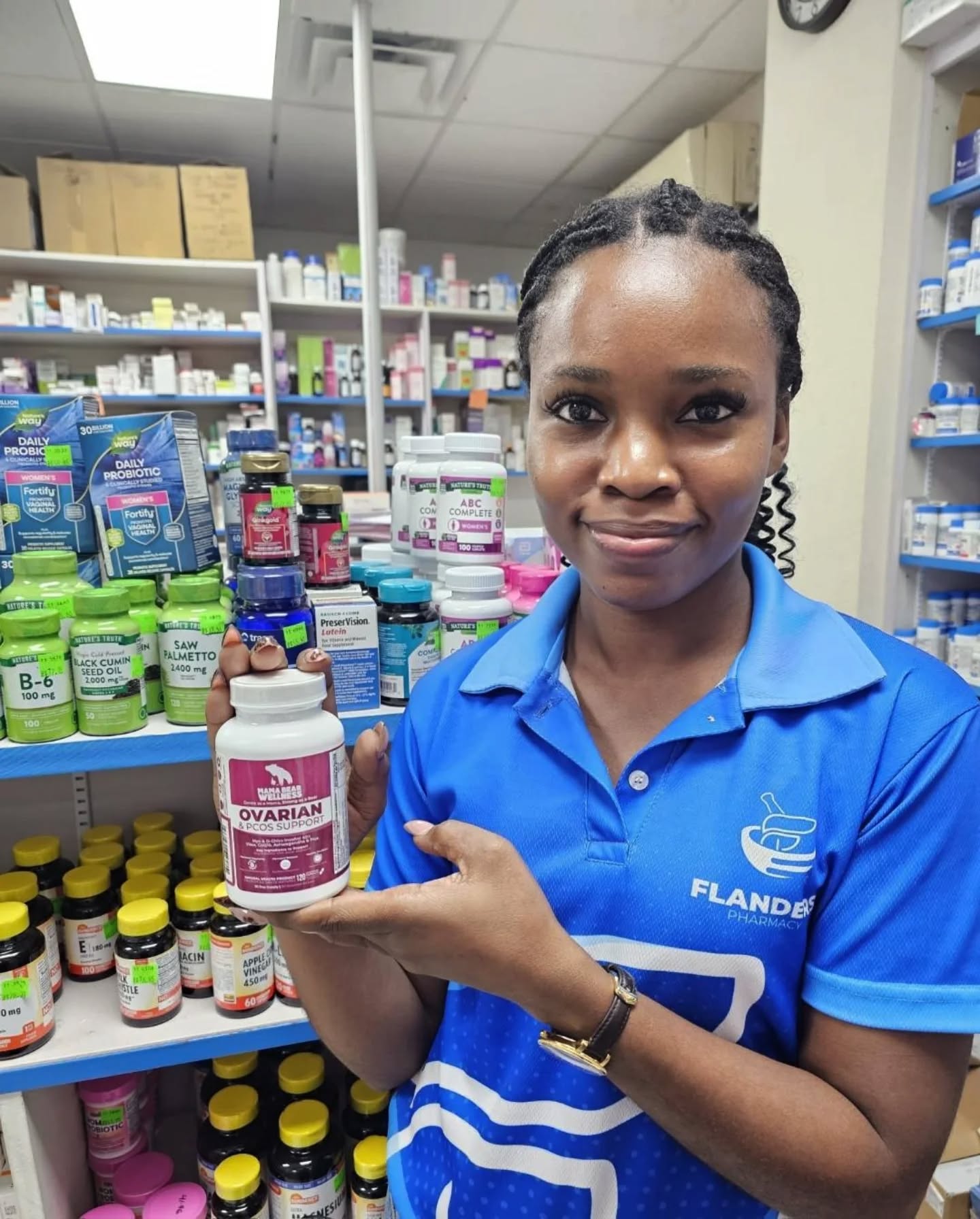 Team member at Flanders Pharmacy in Trinidad presenting a bottle of Mama Bear Ovarian & PCOS Support to the camera